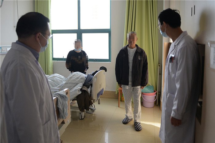 王爹爹下床走动,李威(左)团队观察其下肢肌力、功能恢复情况.JPG 王爹爹下床走动,李威(左)团队观察其下肢肌力、功能恢复情况.JPG