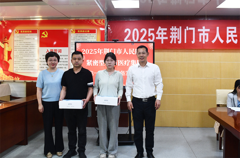 李军华、杨小锐向村卫生室代表发放“心电一张网”设备.JPG